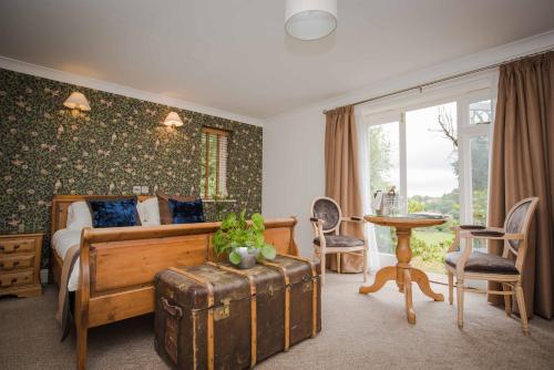 a bedroom with a bed and a table and chairs at Flackley Ash Country House Hotel in Rye