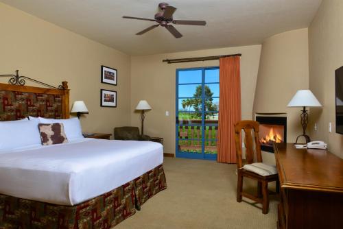 a bedroom with a bed and a desk and a fireplace at Lodge On The Desert in Tucson