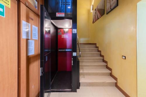 a hallway with stairs and a red elevator at B&B New Aurora Venice in Marghera