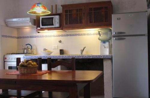 a kitchen with a table and a refrigerator at El Faro de Carpier - ApartHotel & Restaurante Bar Cafetería in Tanti
