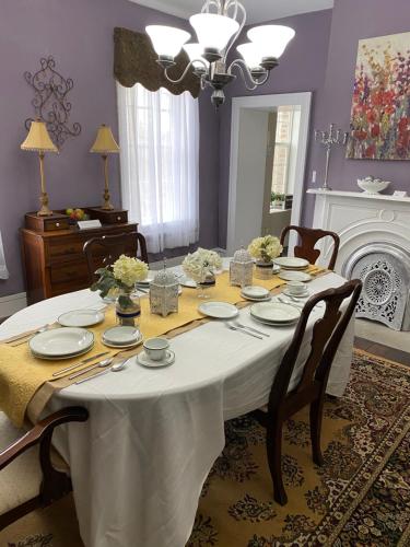 a dining room table with a white tablecloth and chairs at Historic McDonald Airbnb in Attica