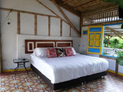 una camera con un grande letto di Hacienda Guayabal a Chinchiná