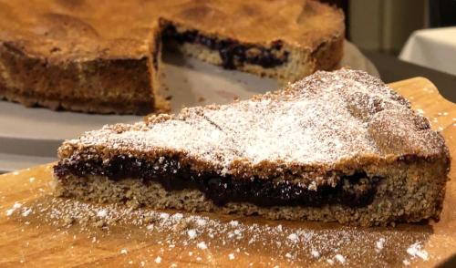 a piece of cake sitting on top of a wooden cutting board at Agriturismo Cavria in Castione Andevenno