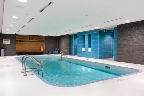 een groot zwembad in een gebouw met blauwe tegels bij Hotel Chateau Laurier Québec in Québec