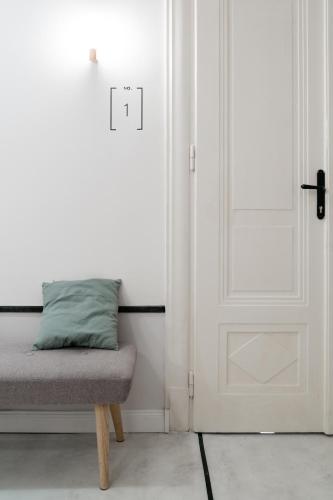 a room with a door and a bench with a pillow at Gellerico Apartments Deák Square in Budapest