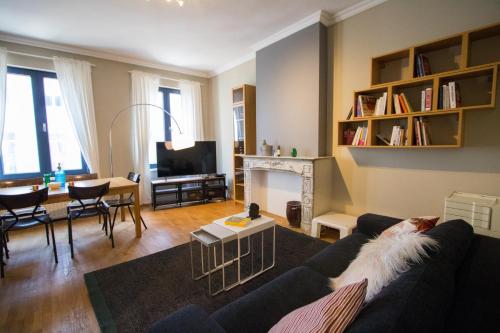 uma sala de estar com um sofá e uma mesa com um cão em Charming Apartments near Avenue Louise em Bruxelas
