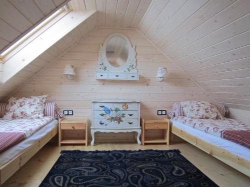 ヴィスワにあるChatki Zielarkiのベッド2台と鏡付きの屋根裏部屋