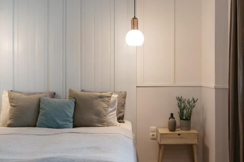 a bedroom with a bed and a pendant light at Gellerico Apartments Deák Square in Budapest