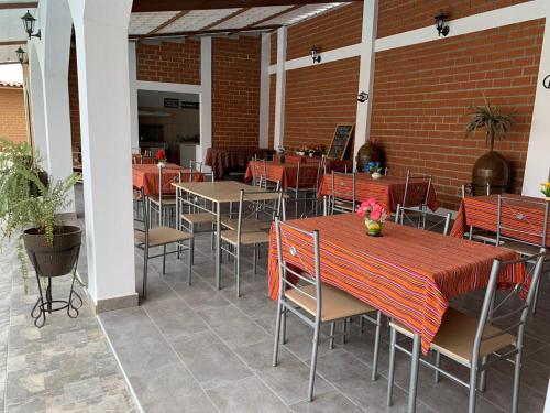 a restaurant with tables and chairs and a brick wall at Huacachina Desert House in Ica