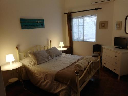 1 dormitorio con 1 cama, 2 lámparas y TV en Casa Mar, en Tavira