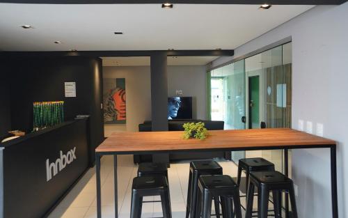 a bar in an office with stools around it at Innbox - Canasvieiras 2 in Florianópolis