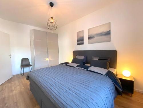 a bedroom with a large bed with a blue blanket at White Inn - Kuschelige Ferienwohnung in Mürzzuschlag