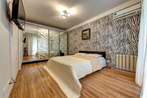 a bedroom with a bed and a tv in it at Excellent apartment Druzhby Narodov boulevard 3a. Lybedskaya metro station in Kyiv