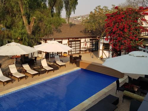 an overhead view of a swimming pool with chairs and umbrellas at Roof of Africa Hotel in Windhoek
