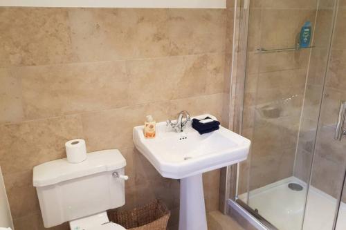 W łazience znajduje się toaleta, umywalka i prysznic. w obiekcie Large 2 ensuite bedroom flat with lovely views w mieście Leeds