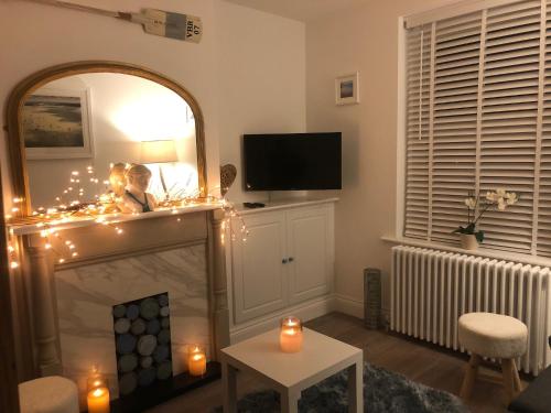 a living room with a fireplace with christmas lights at Seascape Cottage, Ventnor in Ventnor