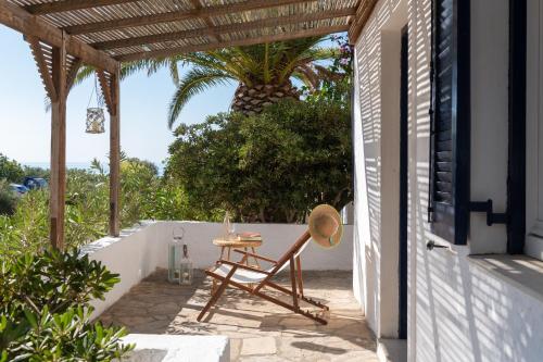 a table and chair on a patio with a palm tree at Margarita Apartments in Ierápetra