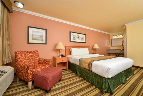 um quarto de hotel com uma cama e uma cadeira em Inn by the sfo em South San Francisco
