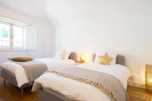 a bedroom with two beds and a window at Lucky Number 79 - UNESCO World Heritage Penthouse in Coimbra