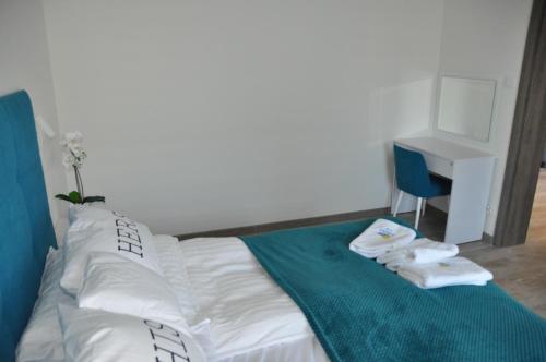 a bedroom with a bed with a blue blanket and a desk at Apartament LAZUROWY Pięć Mórz - Sianożęty in Sianozety