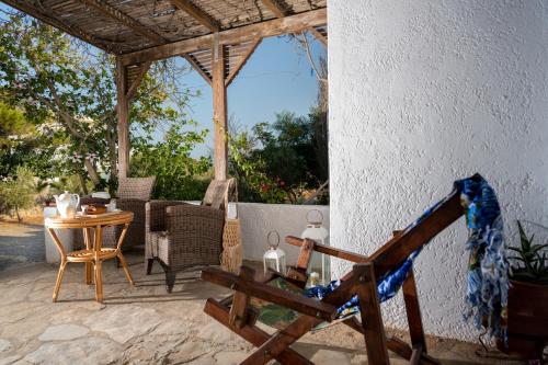 a patio with a table and a chair and a table and chairs at Margarita Apartments in Ierápetra