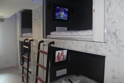 a living room with a fireplace with a tv above it at H-District Boutique Poshotel in Bangkok