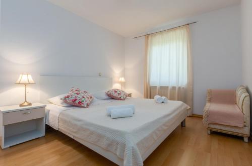1 dormitorio con 1 cama con silla y ventana en Apartment Dino - Three Bedroom Apartment with Pool en Kaldanija