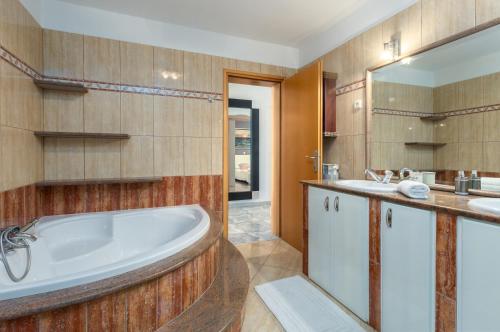 y baño con bañera, 2 lavabos y espejo. en Apartment Dino - Three Bedroom Apartment with Pool en Kaldanija