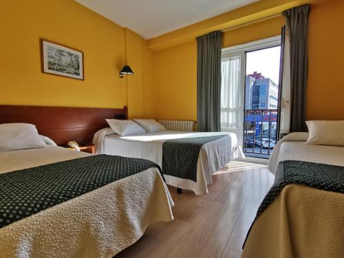 um quarto de hotel com duas camas e uma janela em Hotel San Jacobo em Santiago de Compostela
