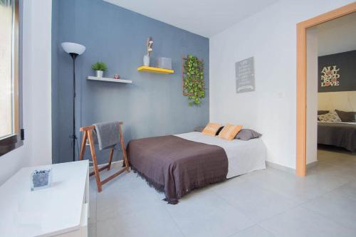 EnjoyGranada REALEJO DELUXE 2A في غرناطة: غرفة نوم بسرير وجدار ازرق