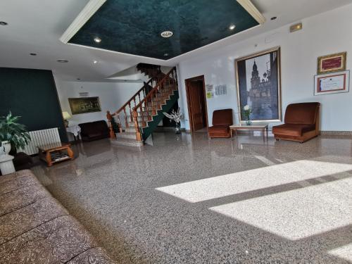 a large living room with a staircase and chairs at Hotel San Jacobo in Santiago de Compostela