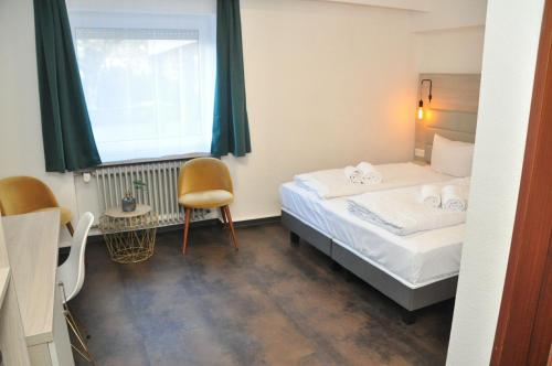 a small bedroom with a bed and a window at Hotel Am Martinsberg in Andernach