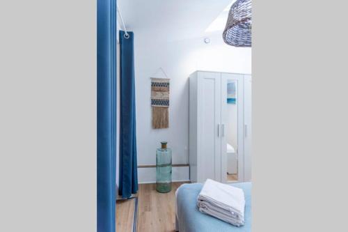 une chambre avec un canapé bleu et un miroir dans l'établissement Appartement 2 personnes, Place St Sauveur à 2min, à Caen