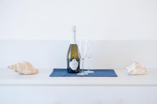a bottle of wine and two glasses on a table at Vento di mare in Procida