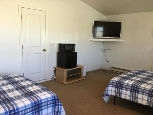 a room with two beds and a flat screen tv at Casita in Pahrump