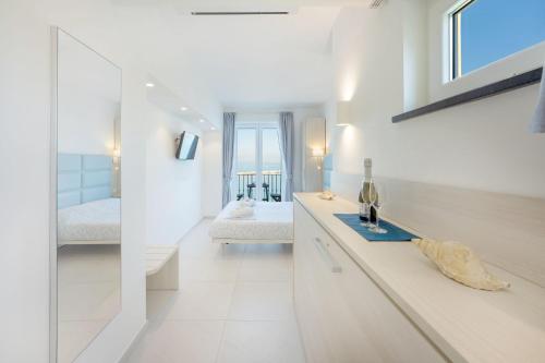 a white kitchen with a counter and a bedroom at Vento di mare in Procida