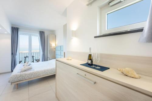 a bedroom with a bed and a window with a bottle of wine at Vento di mare in Procida
