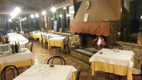 un restaurante con mesas y sillas y una chimenea en Albergo Ristorante Ferretti, en Monteluco