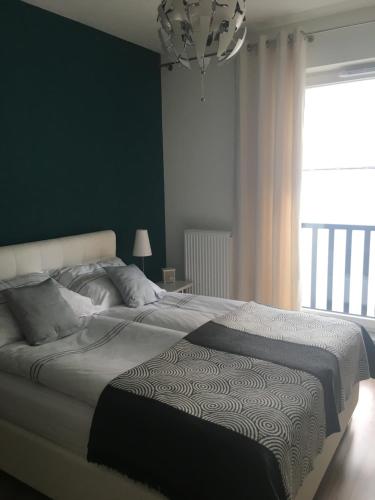 sypialnia z dużym łóżkiem i zieloną ścianą w obiekcie SWING w Szczecinie