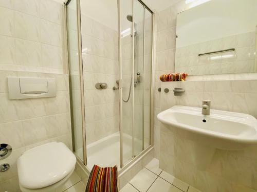 a bathroom with a shower and a toilet and a sink at Villa Caprivi - Ferienwohnung 5 in Heringsdorf