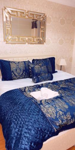 a bed with a blue blanket and a hat on it at Loch Lomond Apartments in Dumbarton