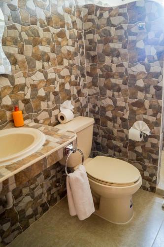 a bathroom with a toilet and a sink at Los Depas del Aeropuerto Holbox in Holbox Island