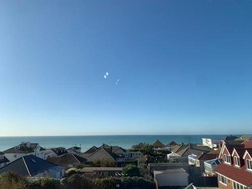 a city with houses and the ocean in the background at The Greenwich Rooms - Burger & Bird Bar & Restaurant in Peacehaven