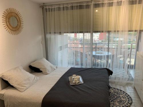 a bedroom with a bed with a view of a balcony at Studio climatisé à 5 minutes de la plage in Le Grau-du-Roi