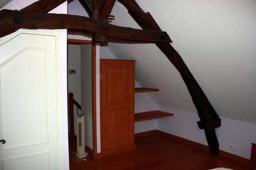 an attic room with a wooden door and stairs at Cottage de La Mothe in Marnac