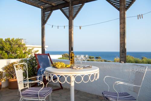 a table and chairs on a patio with the ocean in the background at Margarita Apartments in Ierápetra