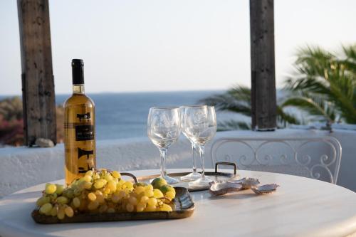 a table with two wine glasses and a plate of grapes at Margarita Apartments in Ierápetra
