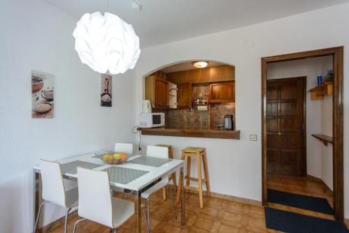a kitchen and dining room with a table and chairs at APPARTEMENT REZ DE JARDIN EMPLACEMENT #1 in Empuriabrava