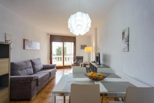 a living room with a couch and a table at APPARTEMENT REZ DE JARDIN EMPLACEMENT #1 in Empuriabrava
