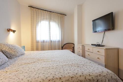 a bedroom with a bed and a flat screen tv at APPARTEMENT REZ DE JARDIN EMPLACEMENT #1 in Empuriabrava